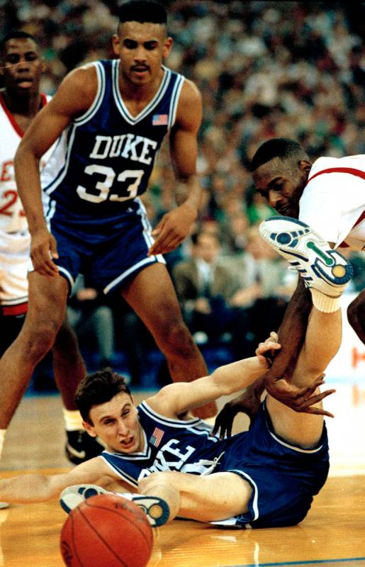 Duke's Bobby Hurley goes to the floor after the basketball as Stacey Augmon of UNLV, right, and ...