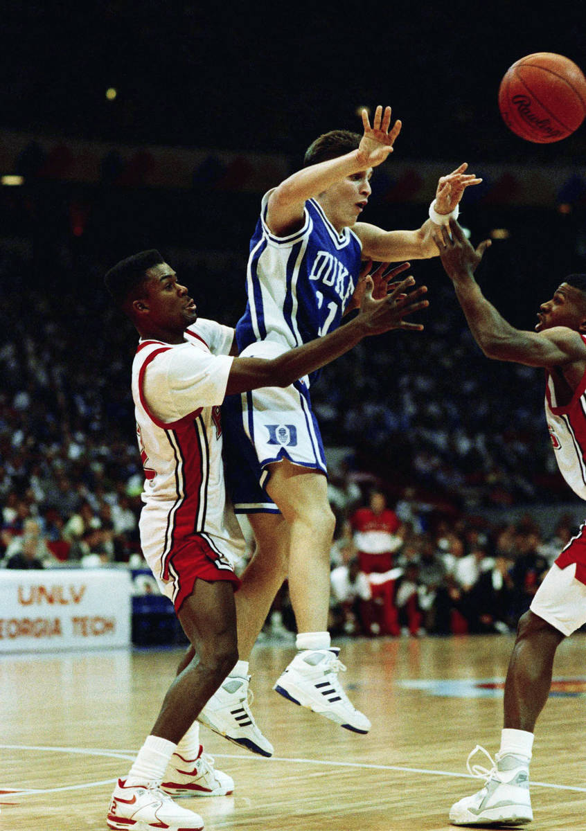 Duke guard Bobby Hurley is trapped by UNLV guard Anderson Hunt (left) and Stacey Augmon (right) ...