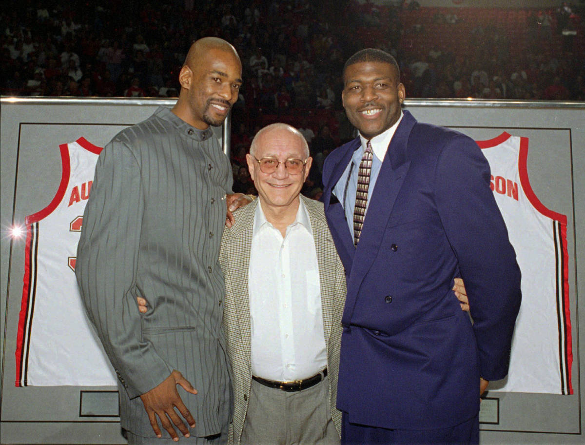 Former UNLV head basketball coach Jerry Tarkanian, center, poses with two of his former star pl ...