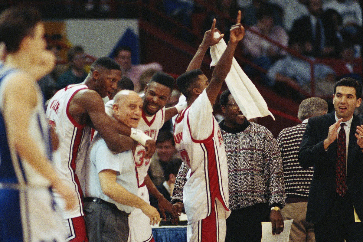 UNLV coach Jerry Tarkanian is hugged by players as the final seconds of the Final Four tick tow ...