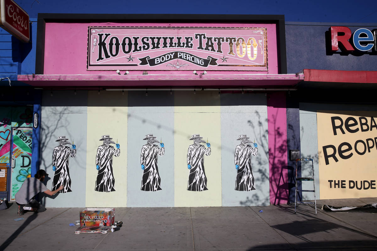 Artist Izaac Zevalking (aka: Recycled Propaganda) of Las Vegas paints a mural on the boarded up ...
