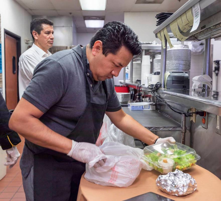 Gaetano's Ristorante waiter Juventino Angeles prepares a to-go order for curbside pickup at the ...