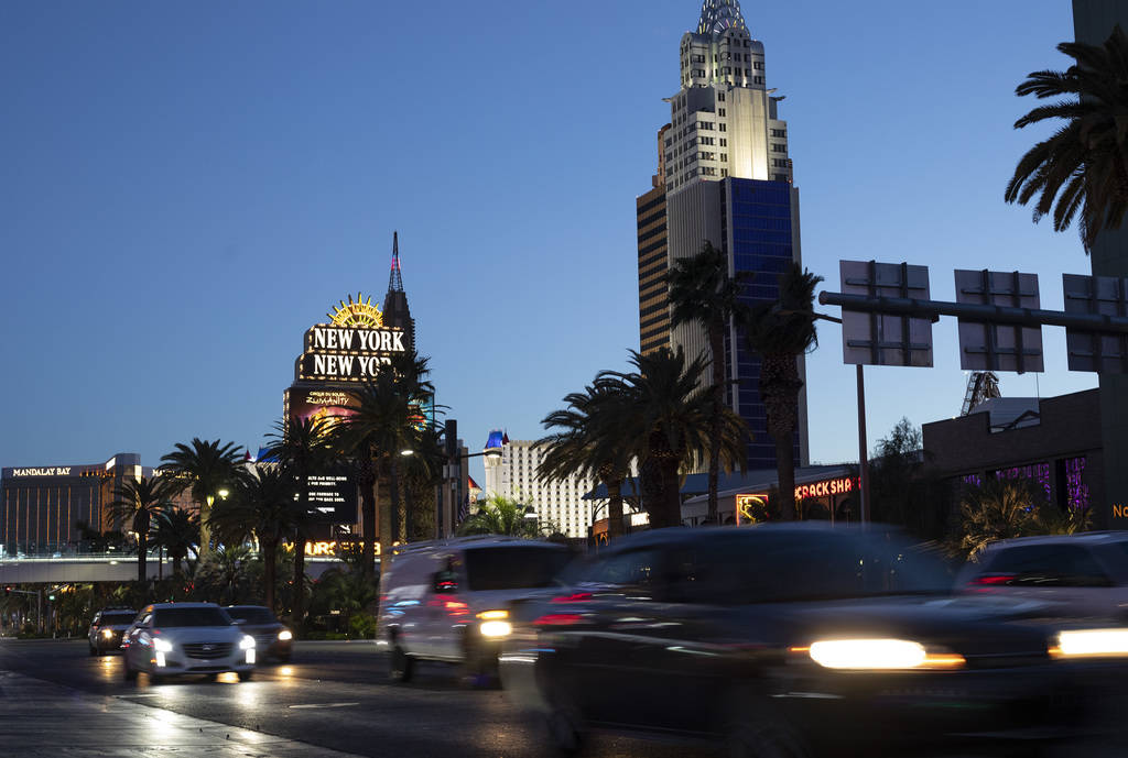 Vehicles pass down Las Vegas Boulevard as New York New York and Mandalay Bay shine in the backg ...