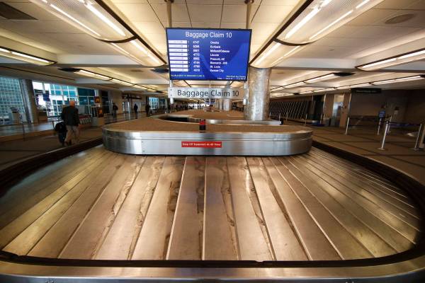 FILE - In this March 20, 2020 file photo, an empty baggage carousel spins in Denver Internation ...