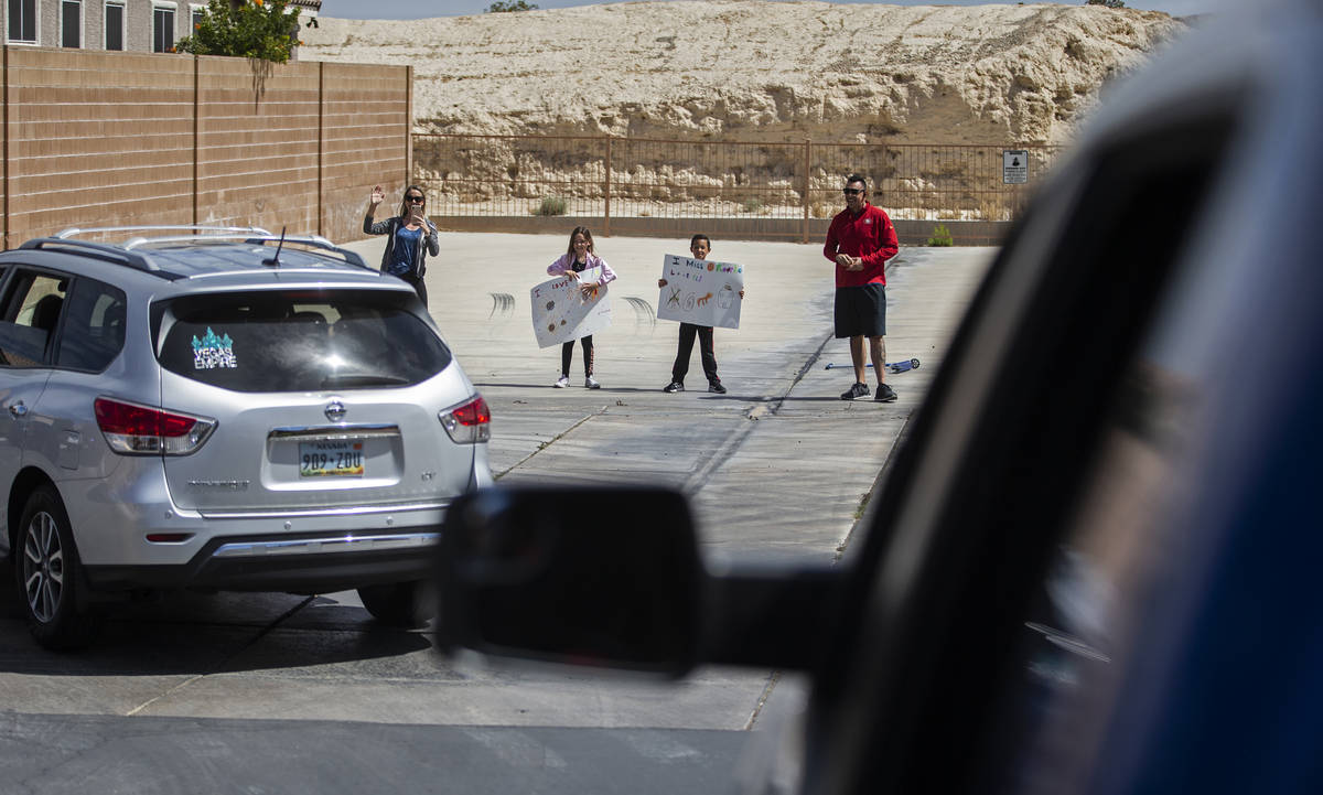 Las Vegas residents wave to teachers and staff from O’Roarke Elementary School who organ ...