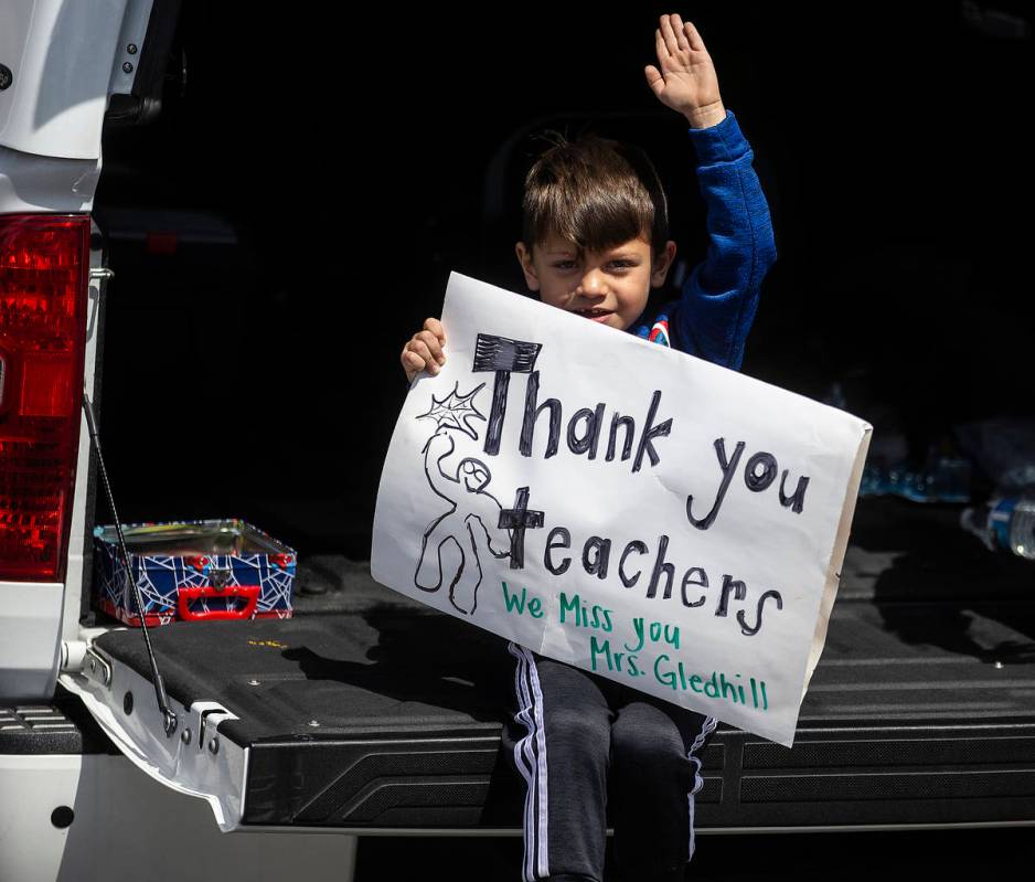 Las Vegas residents wave to teachers and staff from O’Roarke Elementary School who organ ...