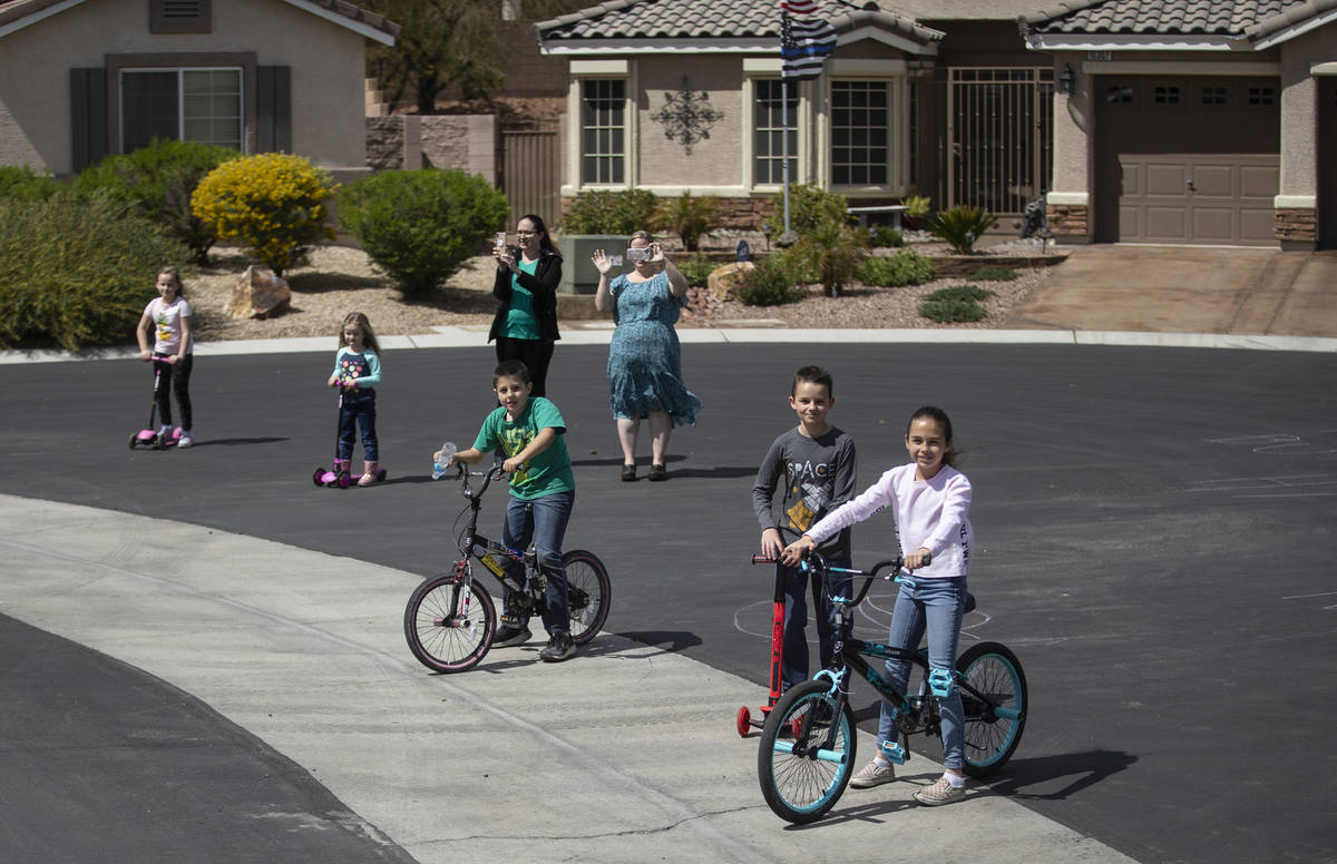 Las Vegas residents wave to teachers and staff from O’Roarke Elementary School who organ ...