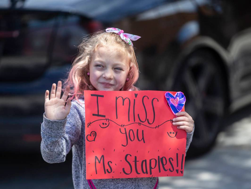 Las Vegas residents wave to teachers and staff from O’Roarke Elementary School who organ ...