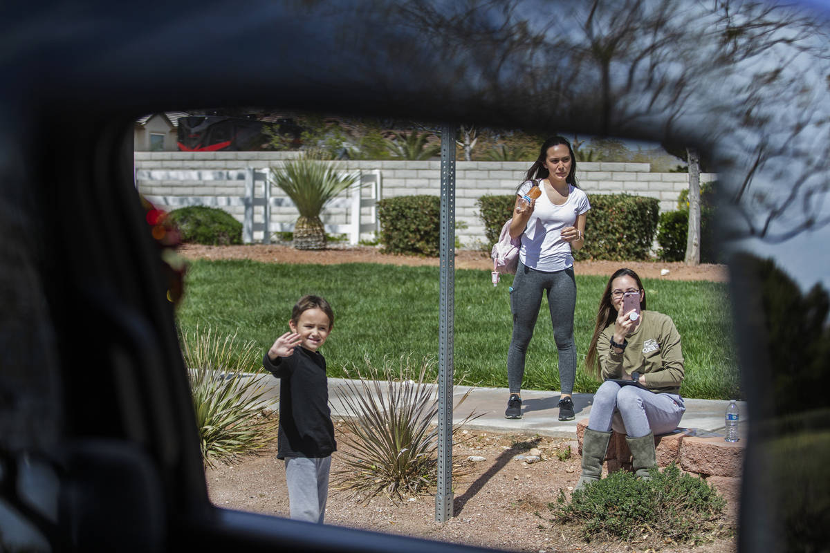 Las Vegas residents wave to teachers and staff from O’Roarke Elementary School who organ ...