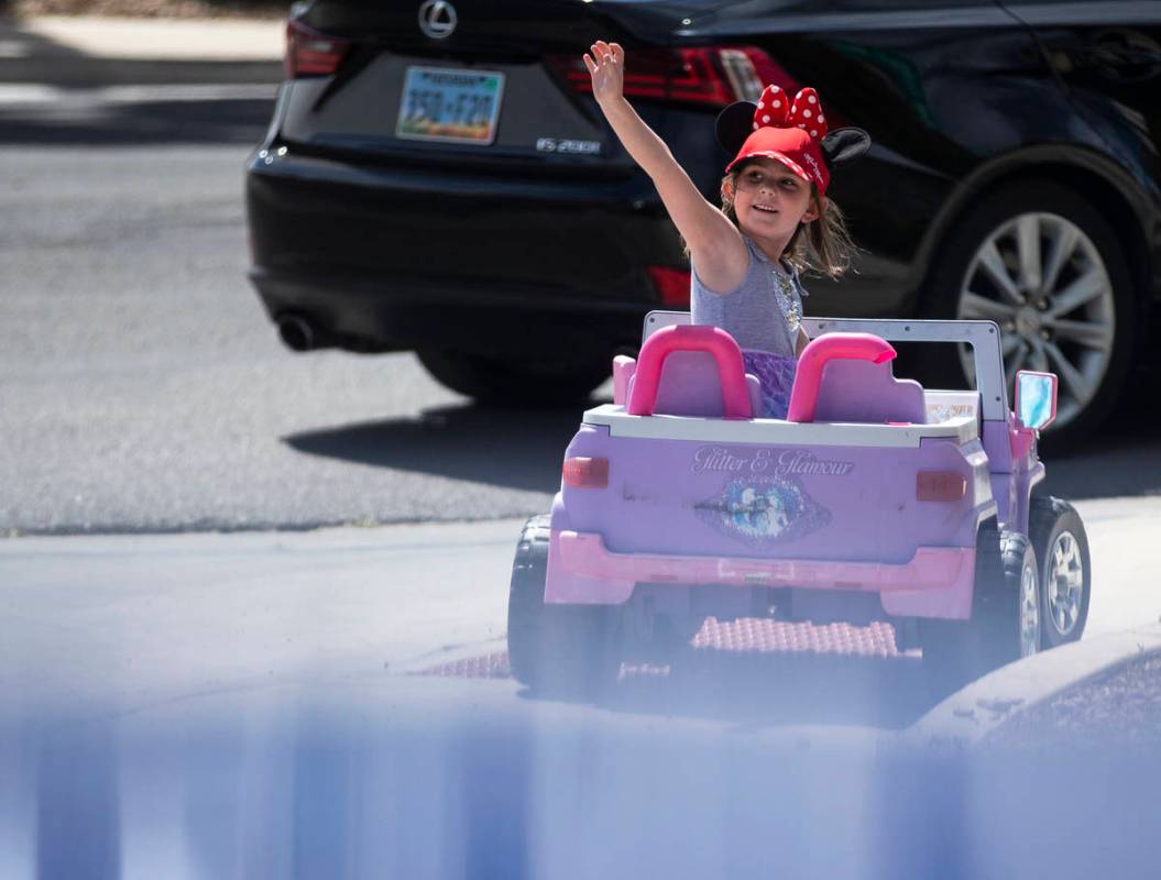 Las Vegas residents wave to teachers and staff from O’Roarke Elementary School who organ ...