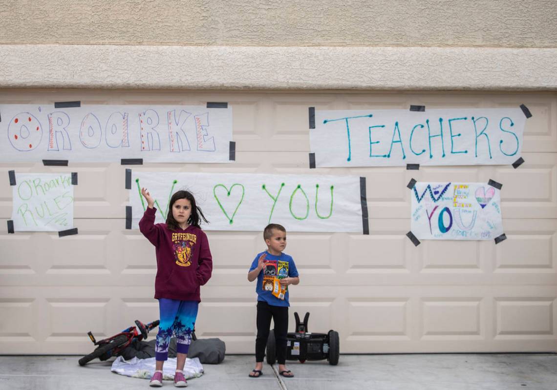 Las Vegas residents wave to teachers and staff from O’Roarke Elementary School who organ ...