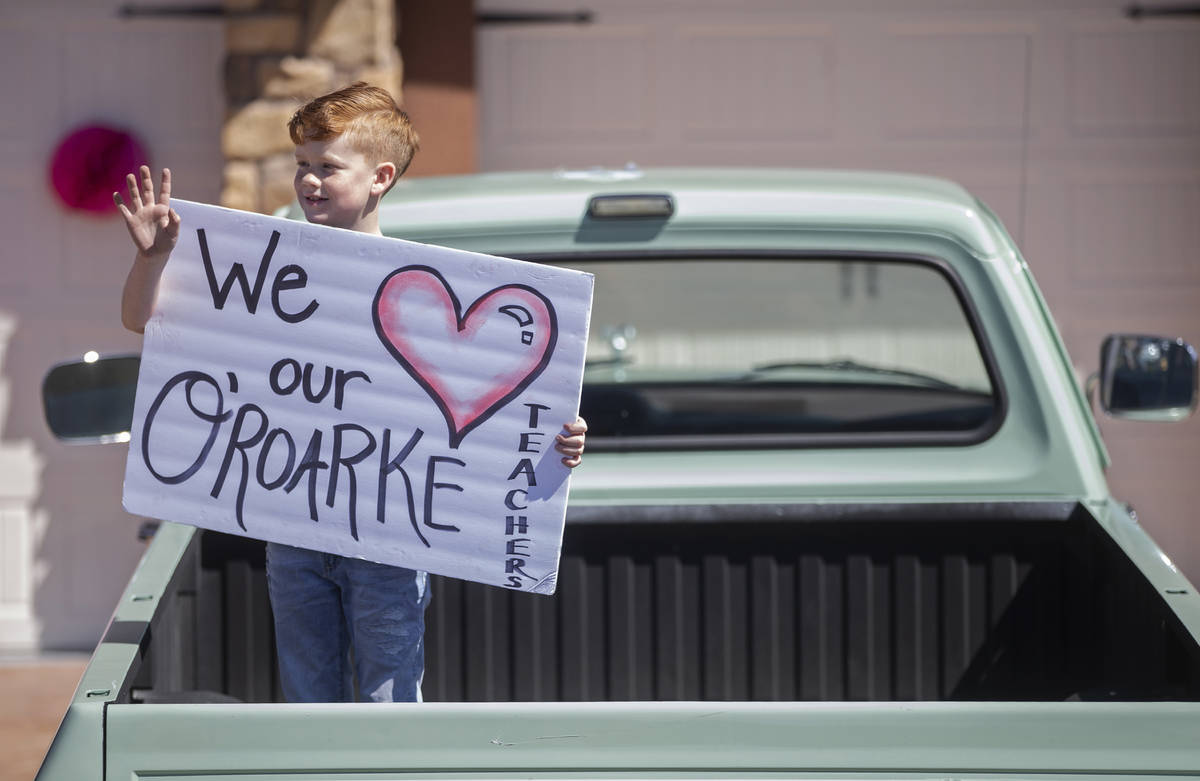 Las Vegas residents wave to teachers and staff from O’Roarke Elementary School who organ ...