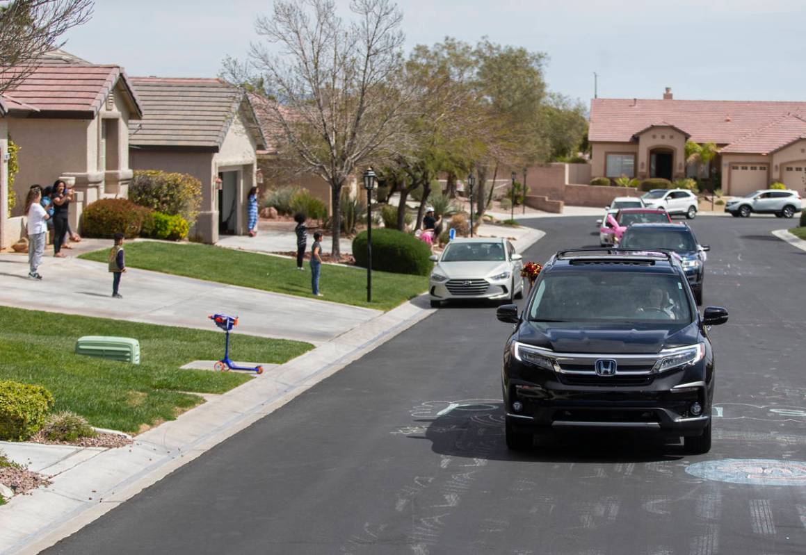 Teachers and staff from OՒoarke Elementary School wave to residents during a parade they ...