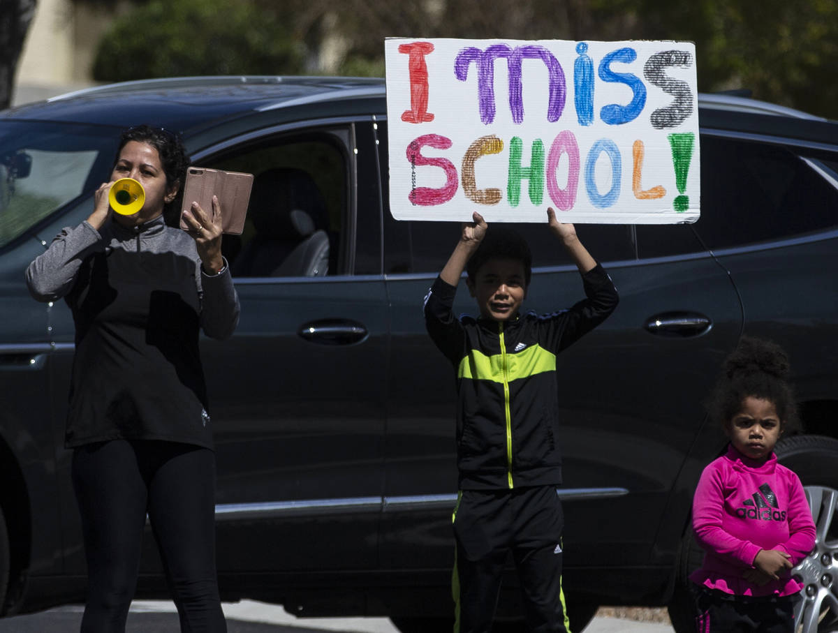 Las Vegas residents wave to teachers and staff from O’Roarke Elementary School who organ ...