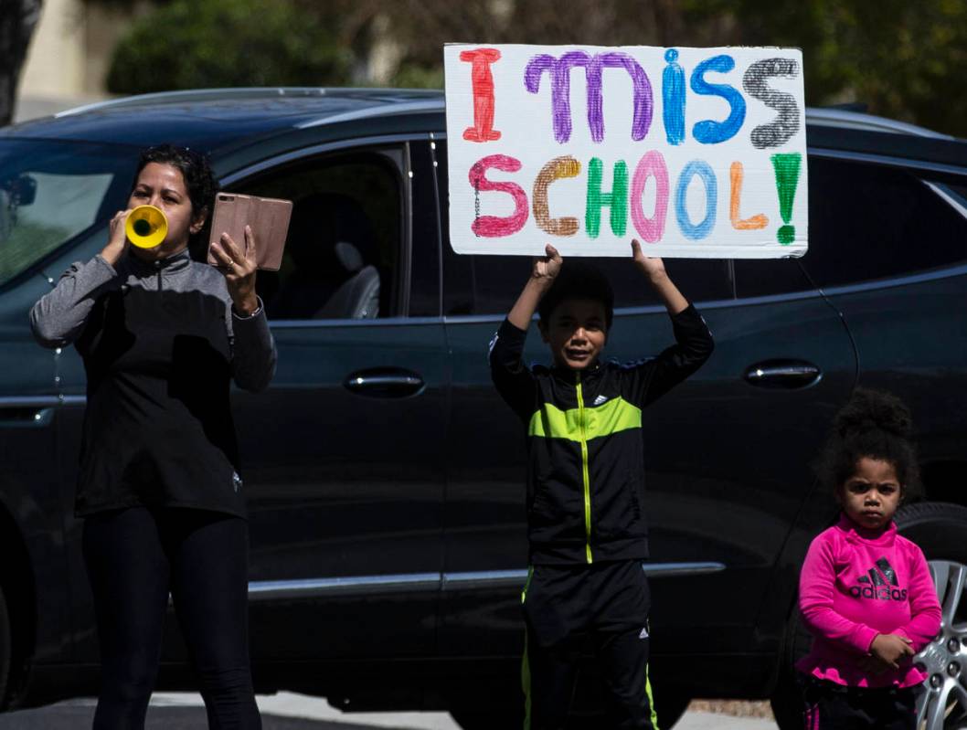 Las Vegas residents wave to teachers and staff from O’Roarke Elementary School who organ ...