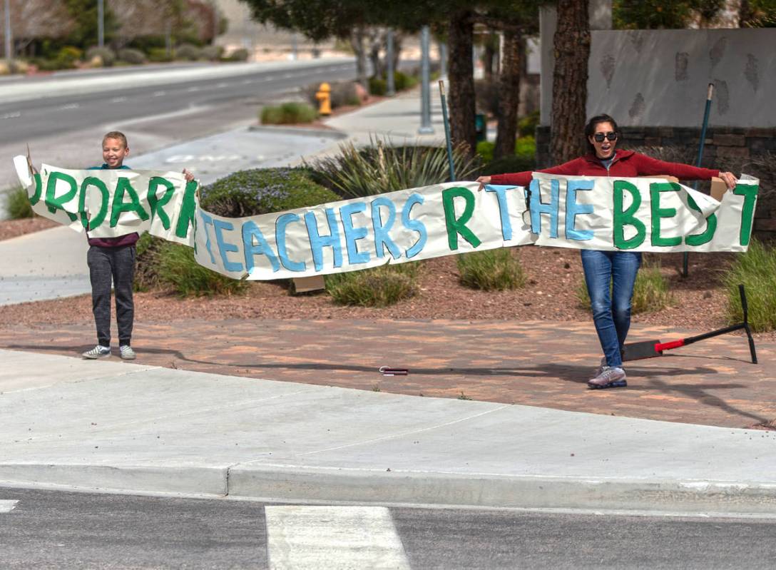 Las Vegas residents wave to teachers and staff from O’Roarke Elementary School who organ ...