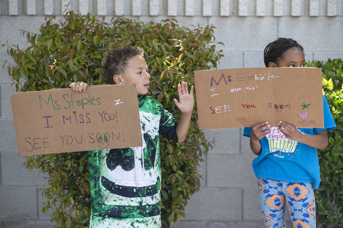 Las Vegas residents wave to teachers and staff from O’Roarke Elementary School who organ ...