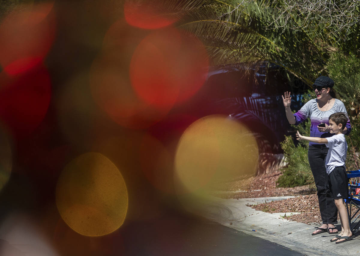 Las Vegas residents wave to teachers and staff from O’Roarke Elementary School who organ ...