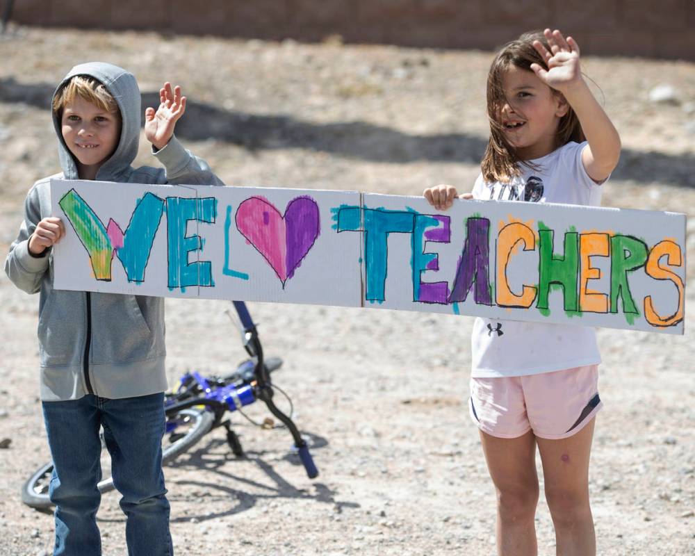 Las Vegas residents wave to teachers and staff from O’Roarke Elementary School who organ ...