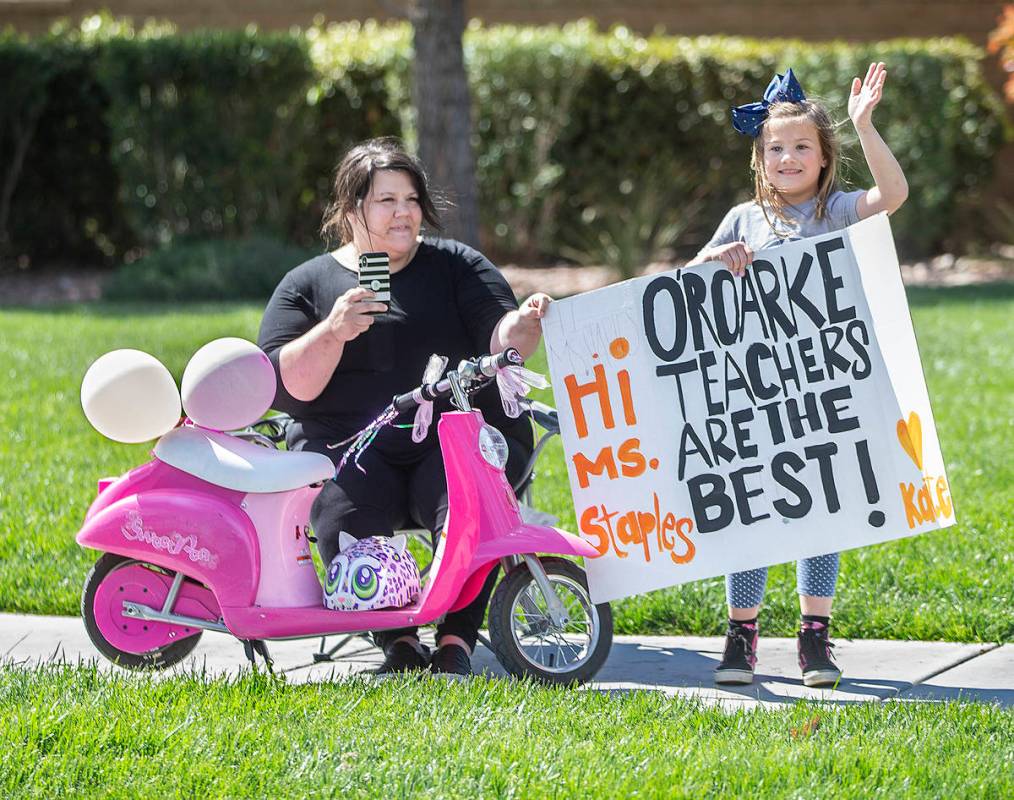 Las Vegas residents wave to teachers and staff from O’Roarke Elementary School who organ ...