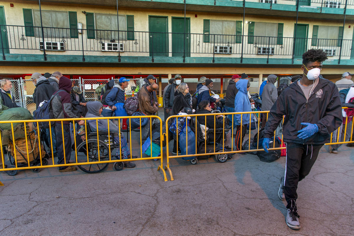 People line up at the Courtyard Homeless Resource Center to receive a sleeping mat for the nigh ...