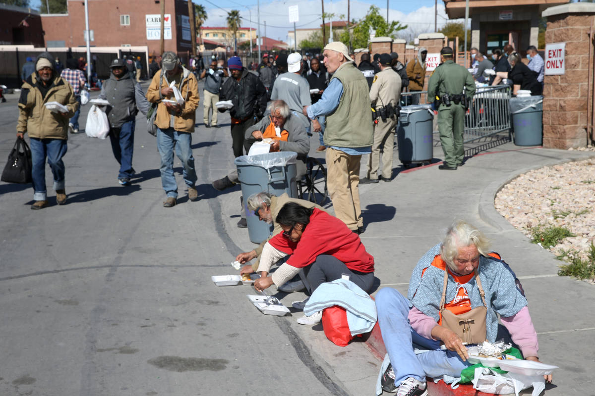 People eat to-go lunches from Catholic Charities on Foremaster Lane in Las Vegas Thursday, Marc ...