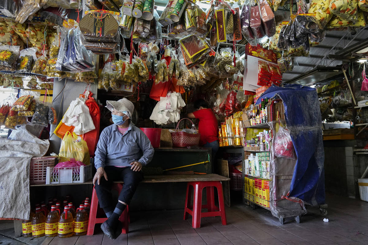 A vendor waits for customers at a market during the movement control order due to the outbreak ...