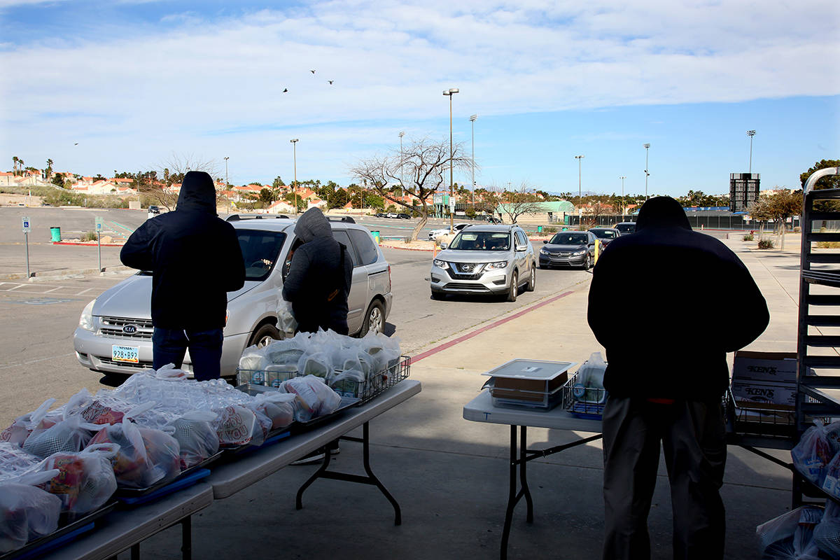 Clark County School District employees help pass out food and homework assignments at Green Val ...