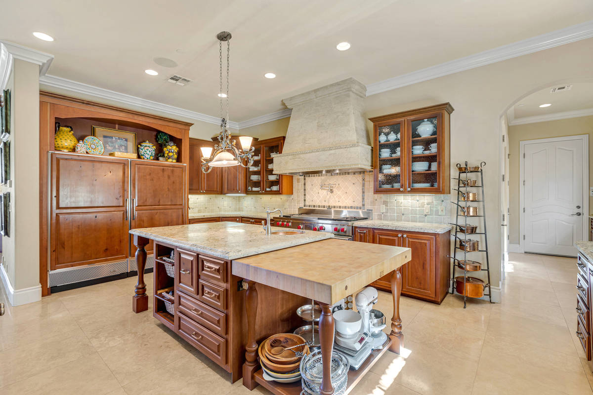 The kitchen features Persia-honed granite counters with beveled edges and an authentic French c ...
