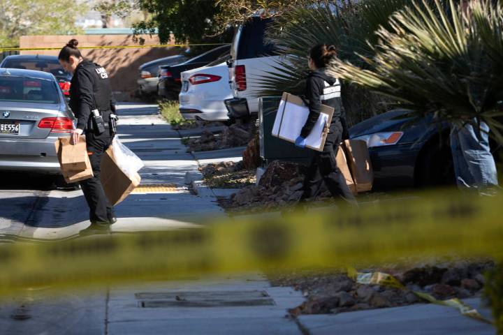 Members of Las Vegas police's crime scene investigative unit carry evidence out of the house wh ...