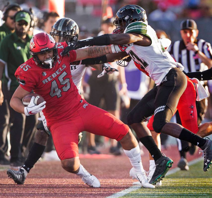 UNLV Rebels tight end Giovanni Fauolo Sr. (45) is knocked out of bounds by Hawaii Warriors defe ...