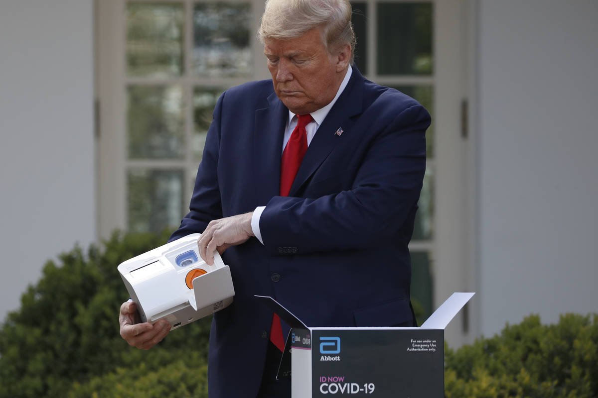 President Donald Trump opens a box containing a 5-minute test for COVID-19 from Abbott Laborato ...