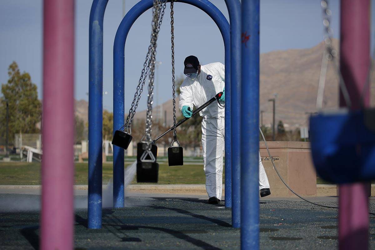 A worker cleans and disinfects playground equipment due to the coronavirus outbreak at a park W ...