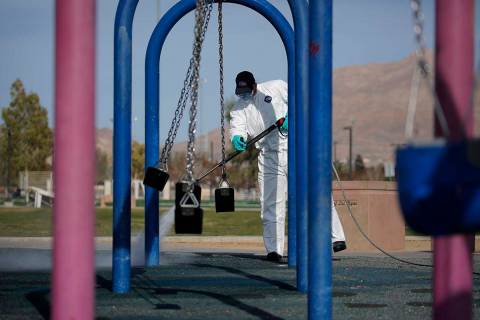 A worker cleans and disinfects playground equipment due to the coronavirus outbreak at a park W ...