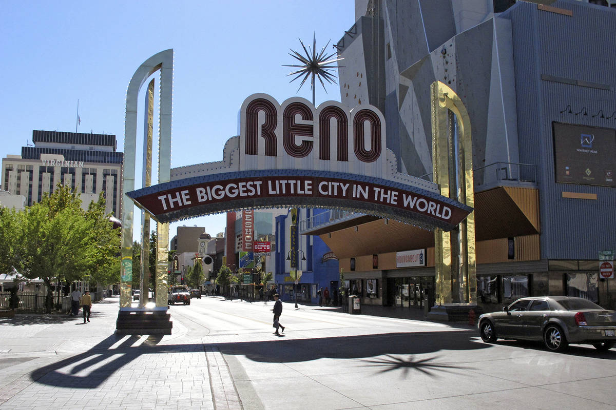 In this Oct. 11, 2016, file photo, pedestrians pass beneath the Reno arch as traffic passes on ...