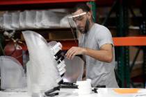 Jonathon Pedrosa, an employee at Faulkner Plastics, assembles plastic face shields used for inf ...