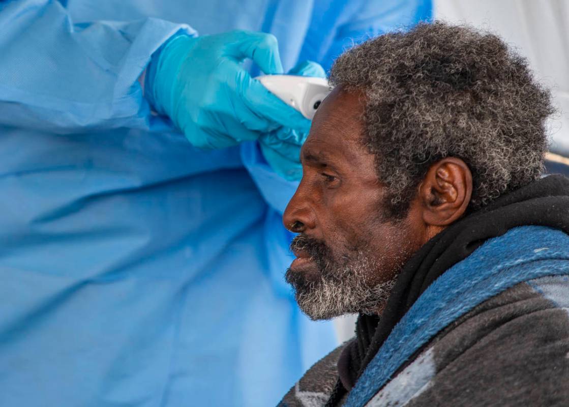 A homeless man has his temperature checked by Touro University Nevada medical student Sami Musa ...