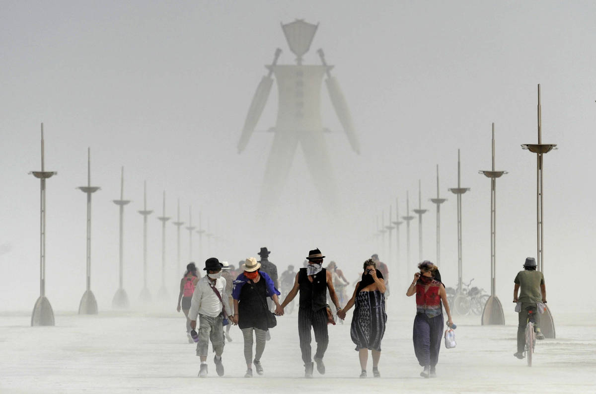 Burning Man participants walk through dust at the annual Burning Man event on the Black Rock De ...