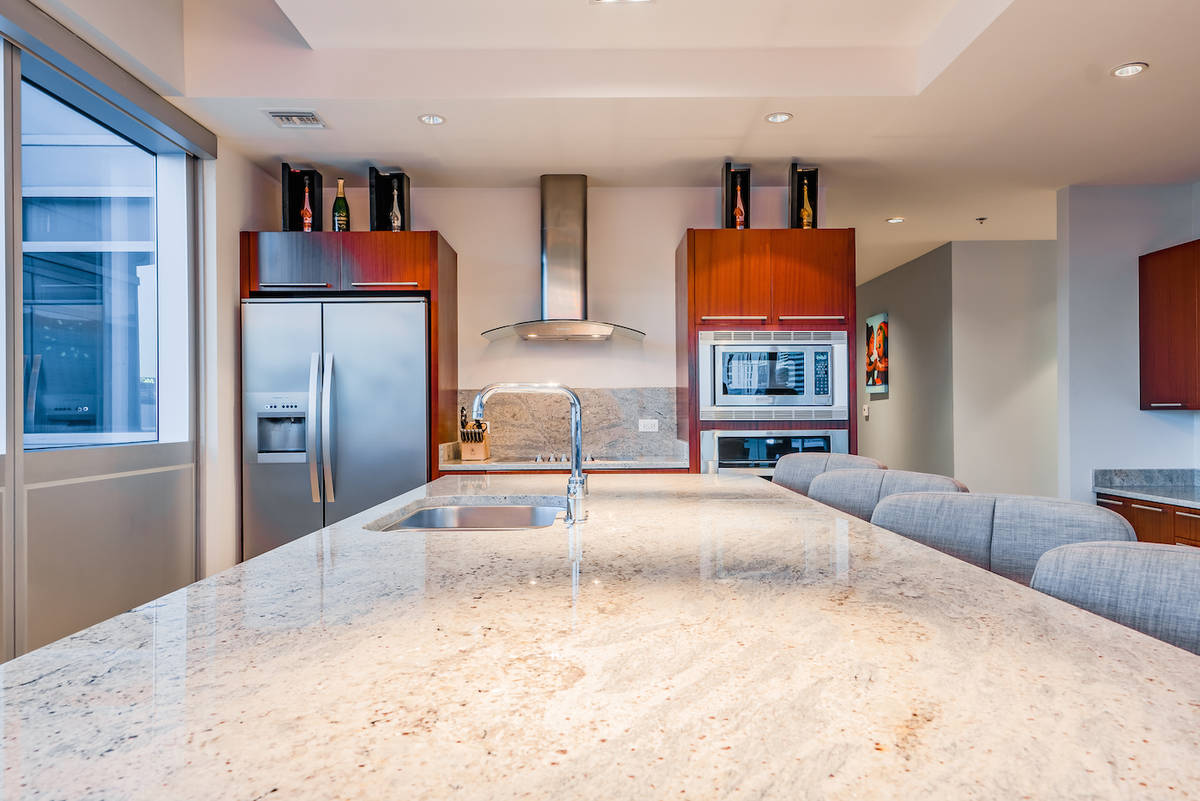 The kitchen showcases an expansive central Kashmir granite island. (Red Luxury Real Estate)