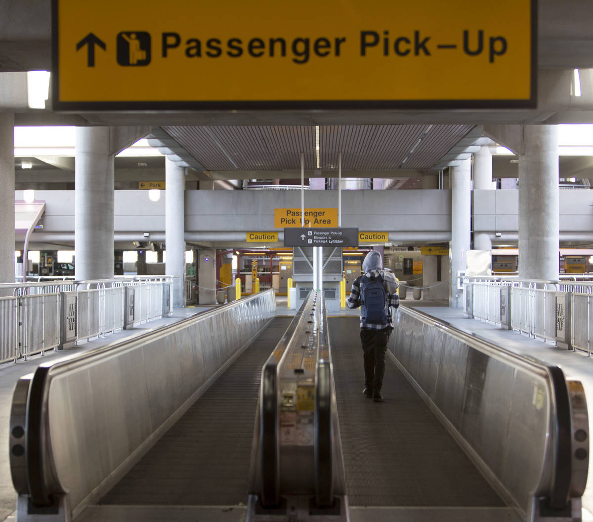 A lone traveler makes way to passenger pickup at McCarran International Airport on Wednesday, A ...