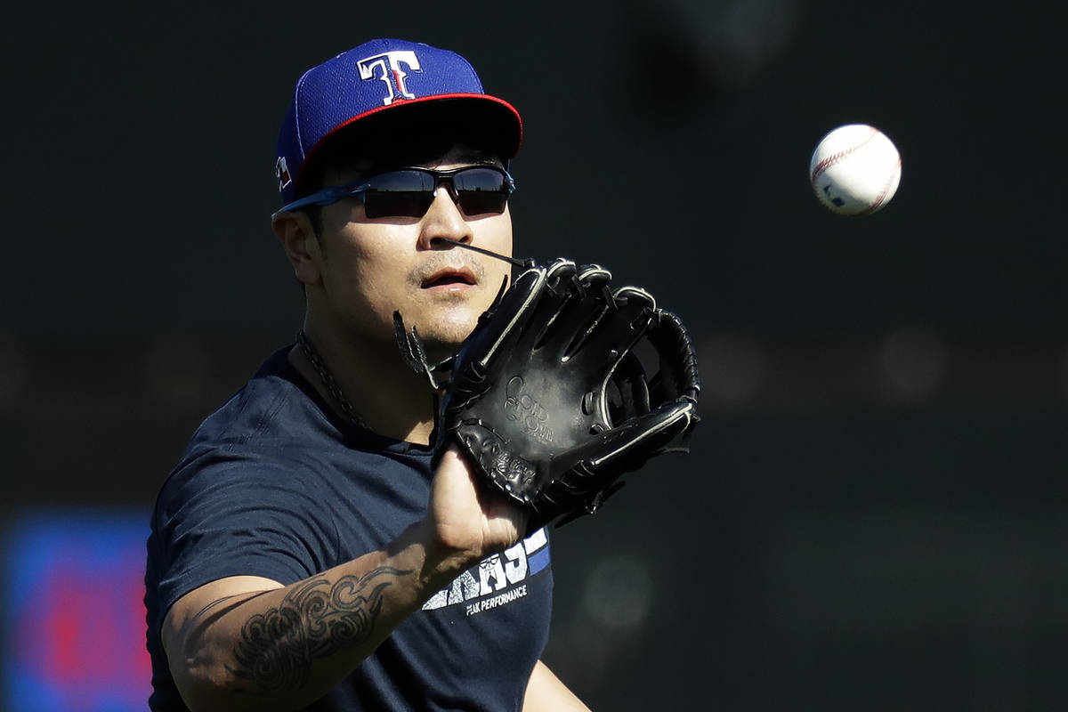 Texas Rangers' Shin-Soo Choo catches a ball during spring training baseball practice Friday, Fe ...