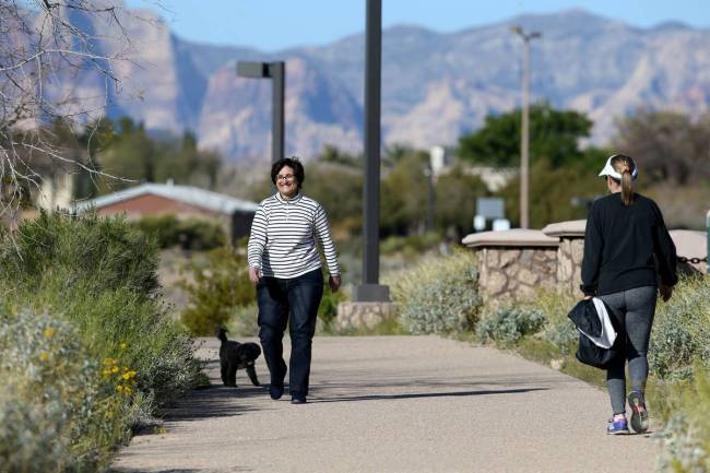 Lisa Lobue and her dog Kendal pass Lois Widell, all of Las Vegas at Hualapai Canyon hiking area ...