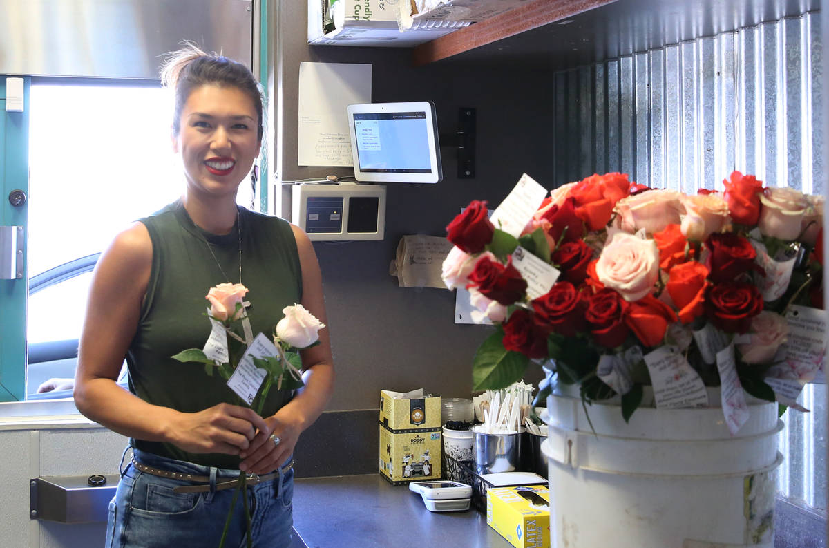 Juanny Romero, owner of Sunrise Coffee, poses for photo before handing out long-stem roses to d ...