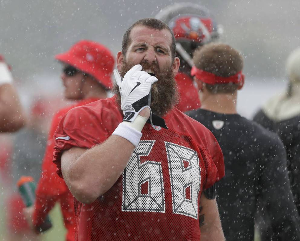 Tampa Bay Buccaneers center Joe Hawley (68) takes off his wet gloves during an NFL football tra ...