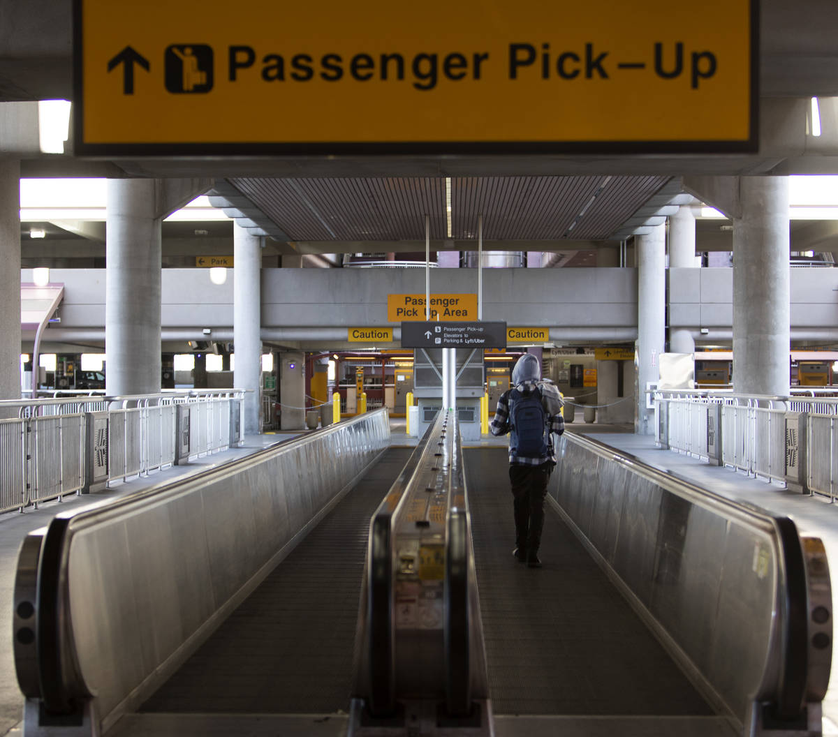 A lone traveler makes way to passenger pickup at McCarran International Airport on Wednesday, A ...