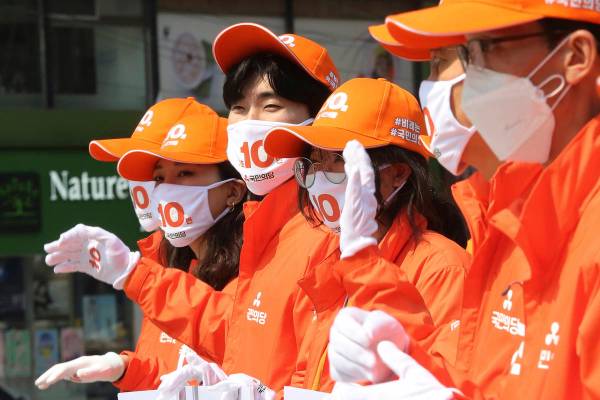 Supporters of the minor opposition People's Party wear face masks to help protect against the s ...