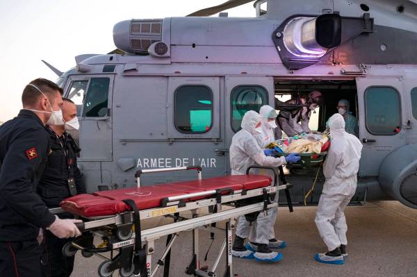 In this photo provided by the French Army Thursday, April 2, 2020, medical staffs evacuate a pa ...