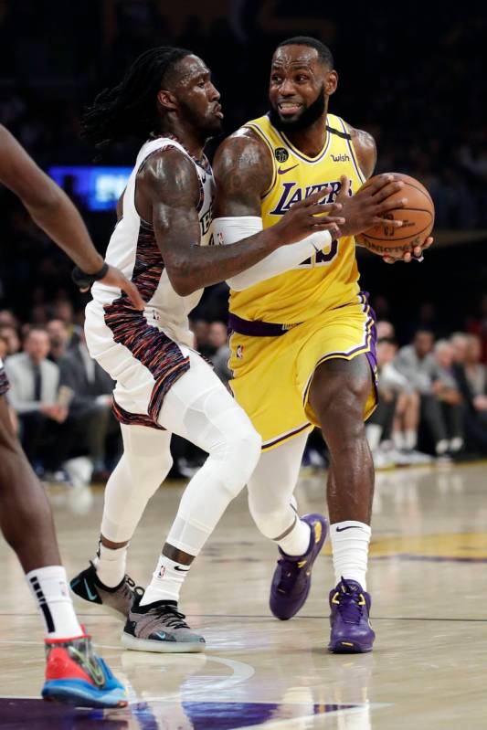 Los Angeles Lakers' LeBron James, right, is defended by Brooklyn Nets' Taurean Prince during th ...