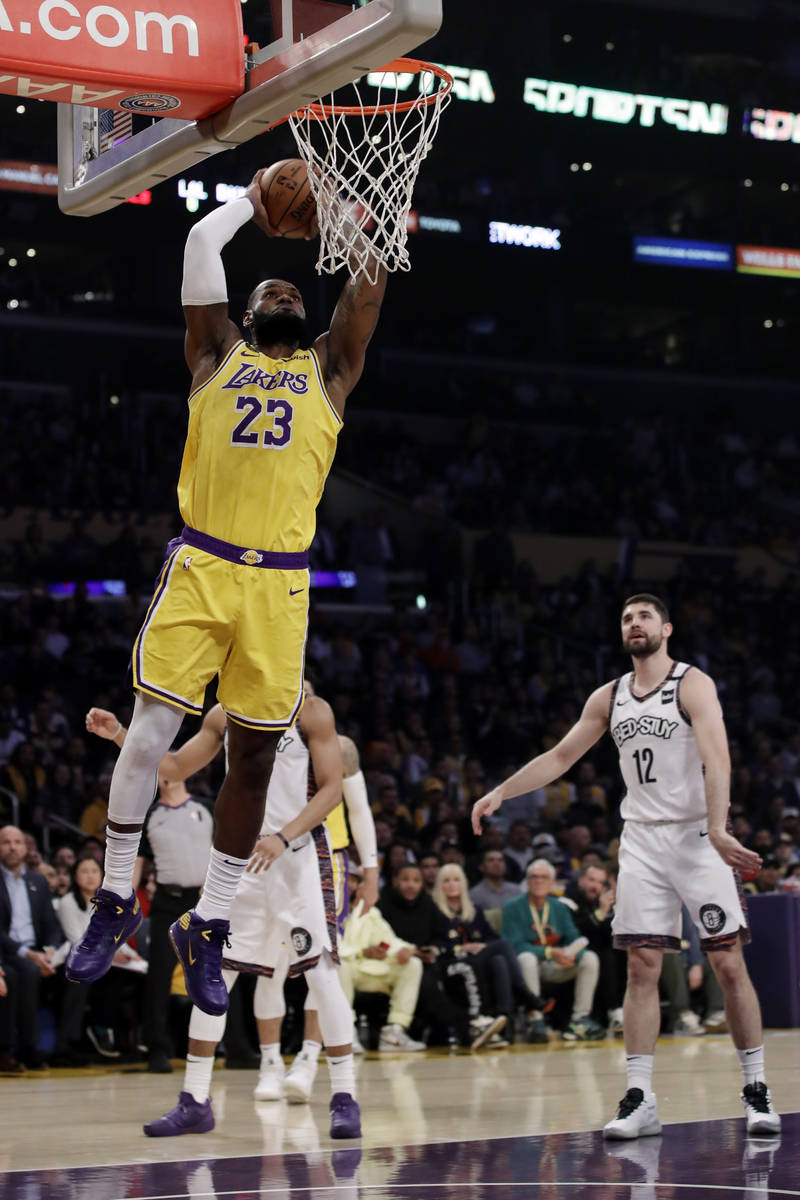 Los Angeles Lakers' LeBron James (23) dunks during the first half of an NBA basketball game aga ...