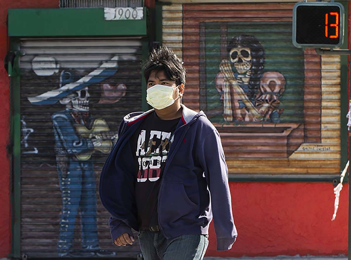 A pedestrian wears a face mask in the Boyle Heights area of Los Angeles on Wednesday, April 1, ...
